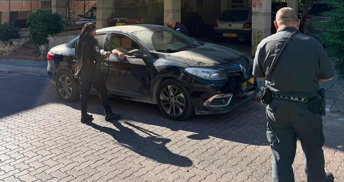 נהג על השפעת סמים ברמת גן. אדם יושב ברכב וליד הרכב שוטרת ושוטר.