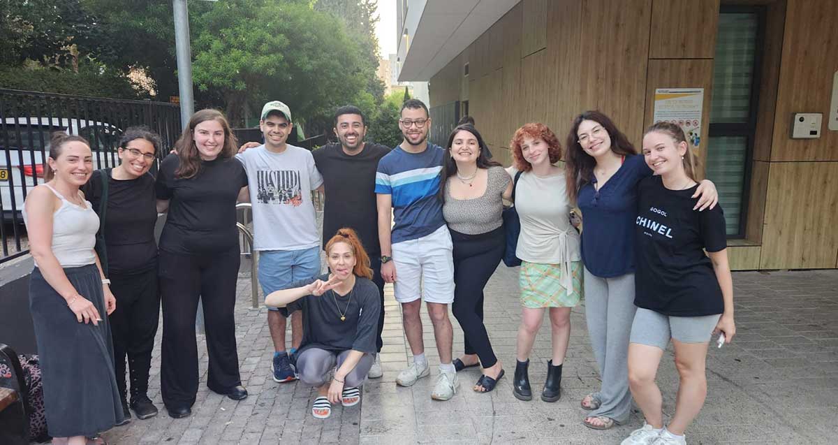 תלמידי בית הספר הדרך עם בוגרי מרכז פלא והמדריכה קורין אפל, בתמונה קבוצתית. המדריכה כורעת במרכז התמונה.