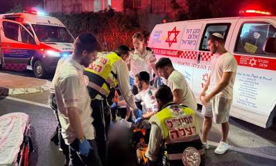 צוות הצלה וצוות מגן דוד אדום מטפלים בפצוע על הכביש מאחוריהם ניידות מגן דוד אדום וניידת הצלה