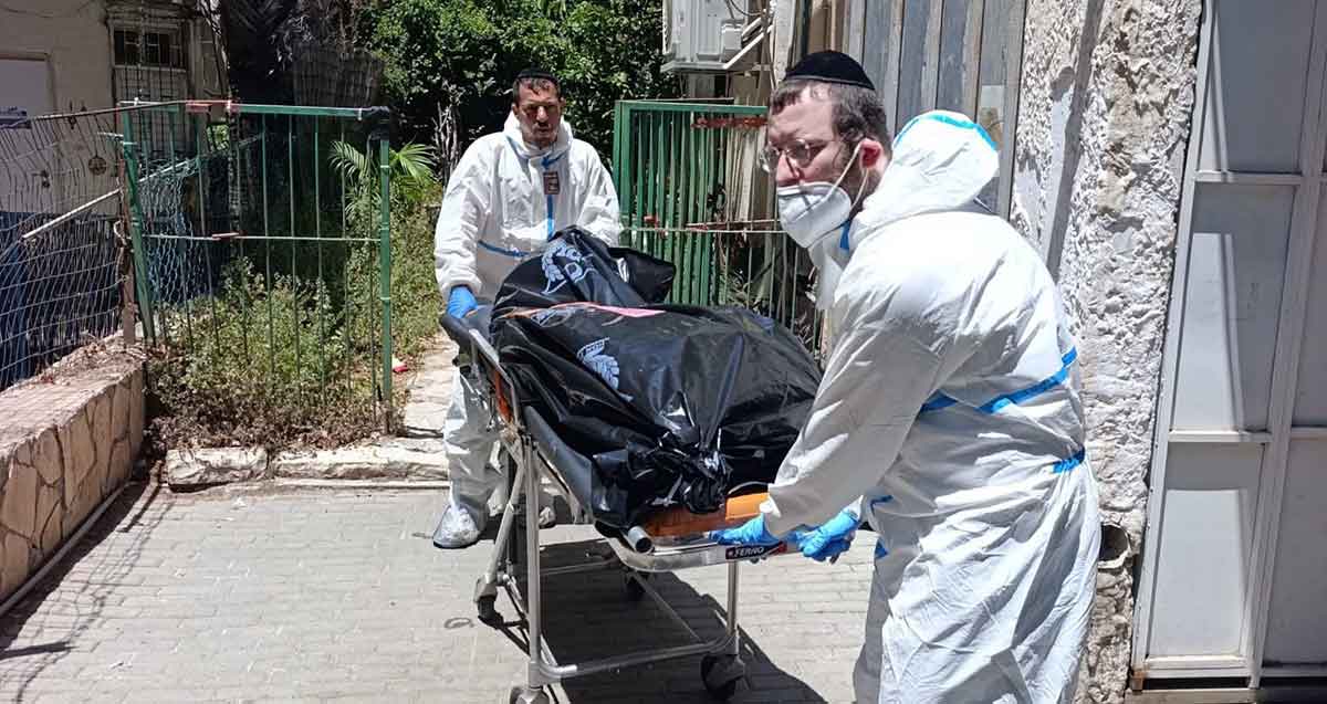 שני אנשי זקא מפנים גופת גבר מגבעתיים. הפינוי על גבי אלונקה. הגופה עטופה בניילון שחור